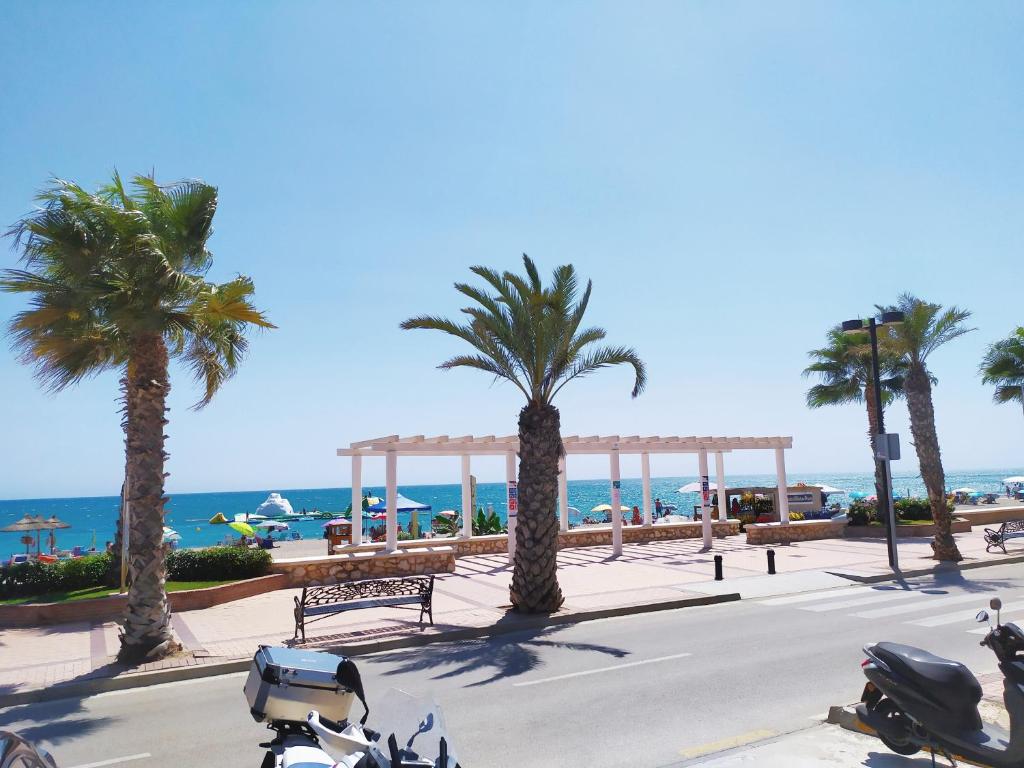 eine Gruppe von Motorrädern, die auf einer Straße mit Palmen geparkt sind in der Unterkunft Apartamento Carvajal Beach in Fuengirola