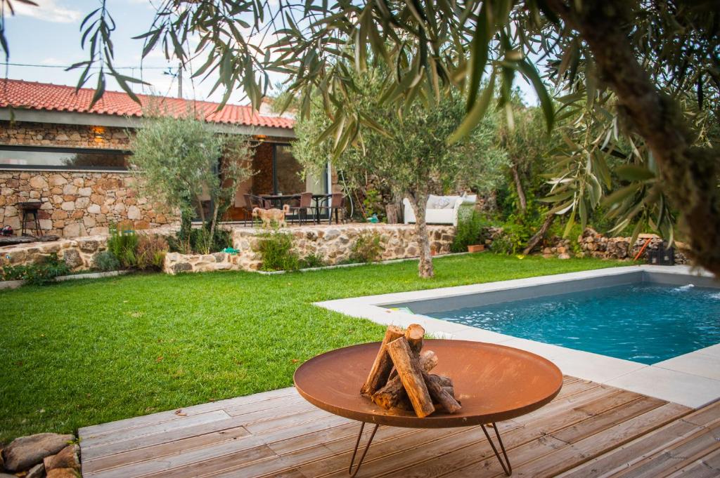 un patio trasero con una mesa y una piscina en Casa do Manel, en Trancoso