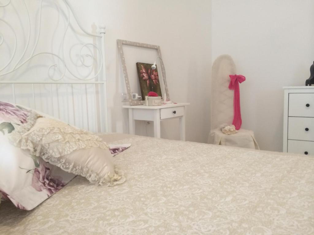 - une chambre avec un grand lit blanc et des oreillers roses dans l'établissement Azzurramare Bed & Breakfast, à Grottammare