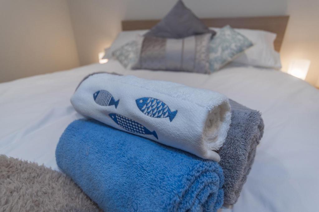 Una cama con toallas encima. en Seashells Cottage, en Lytham St Annes