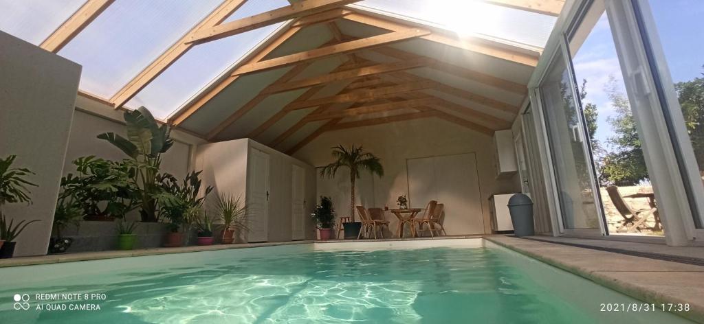 a swimming pool in a house with a roof at Chez Marek et Urszula in Le Langon