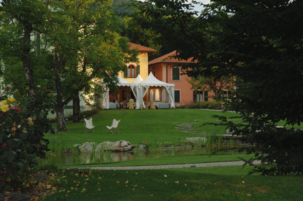 ein Haus mit einem Zelt und Stühlen im Hof in der Unterkunft La Locanda Del Notaio in Pellio Inferiore