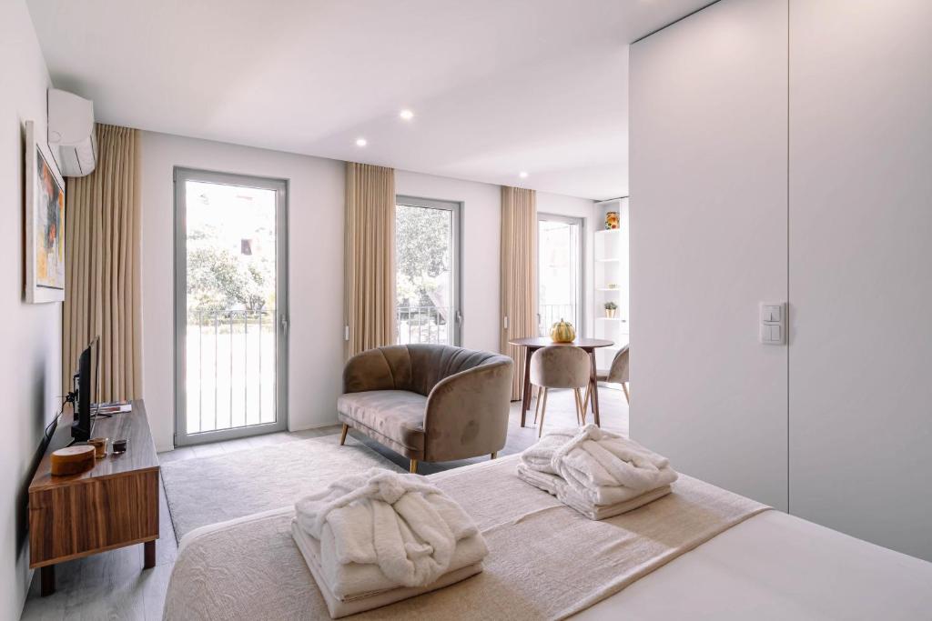 una camera con letto, sedia e tavolo di BBA Apartments Palácio II - Garden View & Parking a Porto
