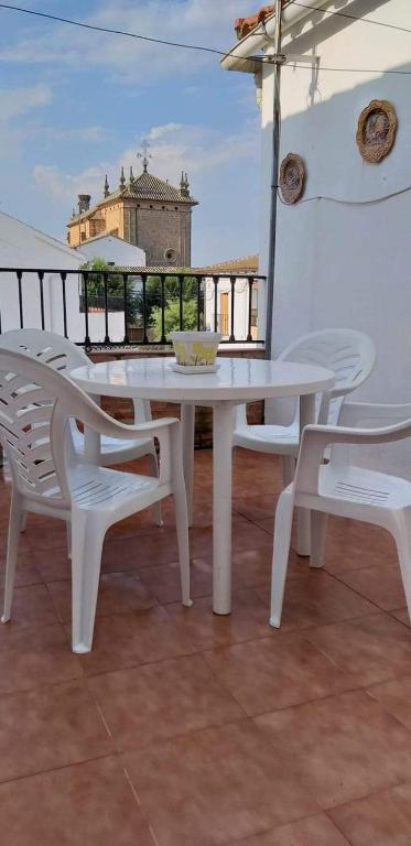 a white table and chairs on top of a balcony at Casa de la Gloria in Baños de la Encina