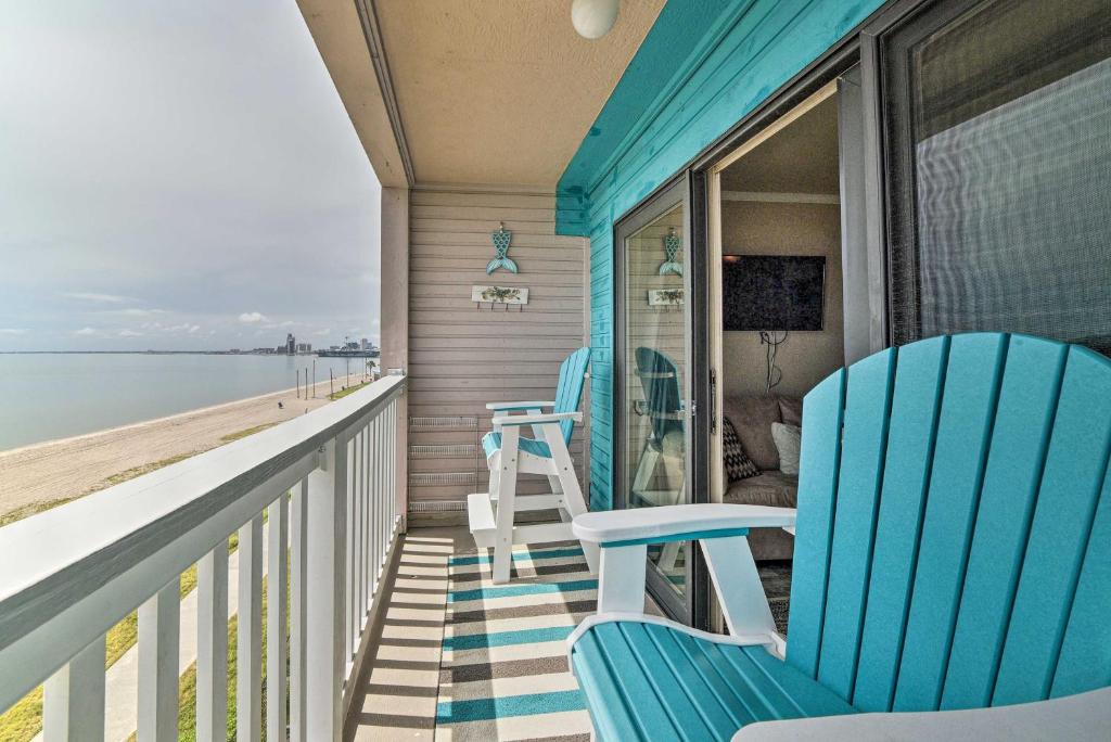 a porch with two blue chairs and the ocean at Updated Front Beach Condo with Resort Amenities! in Corpus Christi