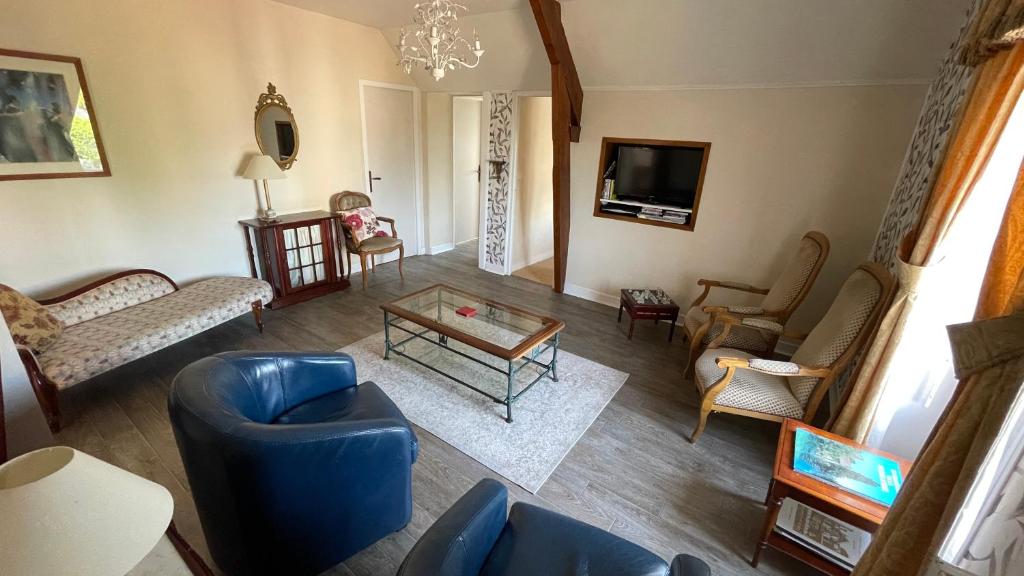 a living room with a blue couch and chairs at Le Grand Chalet in Bagnoles de l&#39;Orne