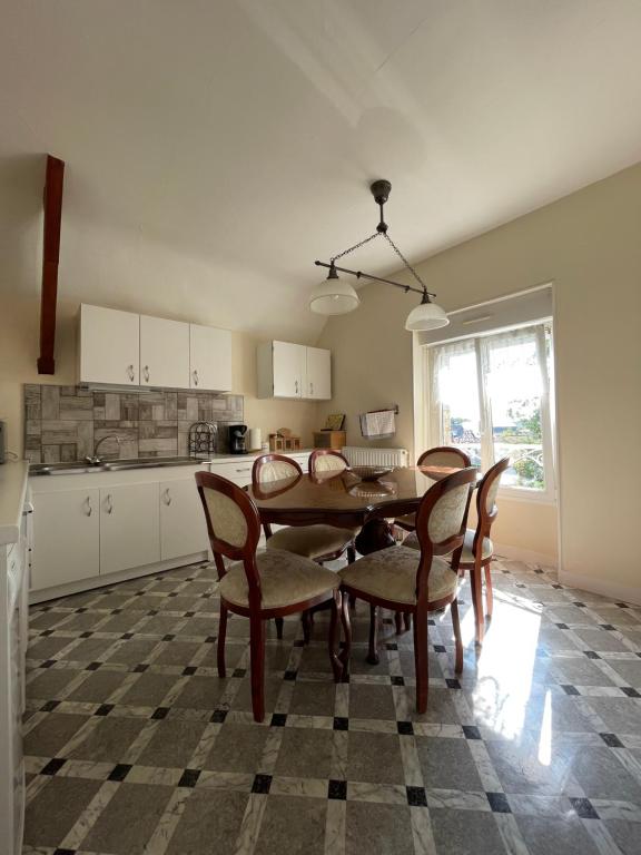 a kitchen with a dining room table and chairs at Le Grand Chalet in Bagnoles de l&#39;Orne