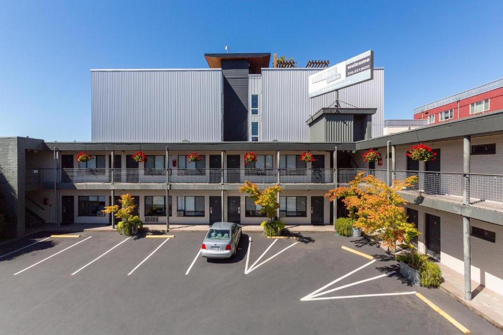 a car parked in a parking lot in front of a building at The Grove West Seattle Inn in Seattle