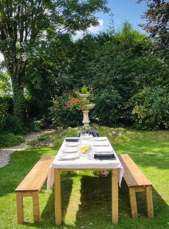 a picnic table with a vase on top of it at Le Grand Chalet in Bagnoles de l&#39;Orne