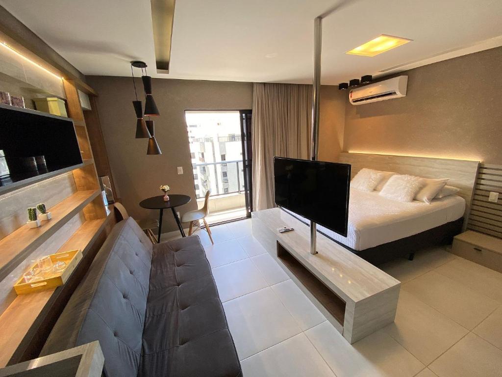 ein Hotelzimmer mit einem Bett und einem TV in der Unterkunft Edifício Time Apto 916 ER Hospedagens in Maceió