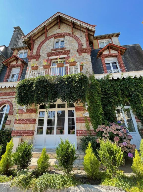 a large brick house with ivy on it at Le Grand Chalet in Bagnoles de l&#39;Orne