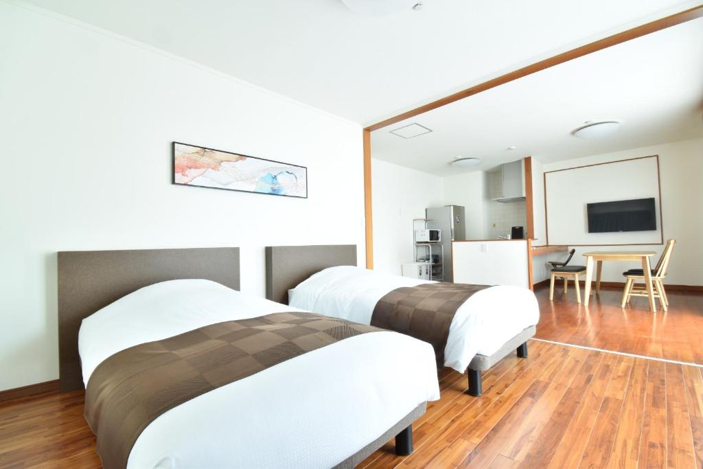 um quarto de hotel com duas camas e uma televisão de ecrã plano em YADO Kukkal- Vacation STAY 48433v em Amami