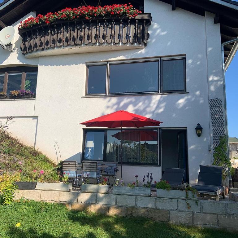 a red umbrella sitting in front of a house at Ferienwohnung Klosterblick in Ühlingen-Birkendorf