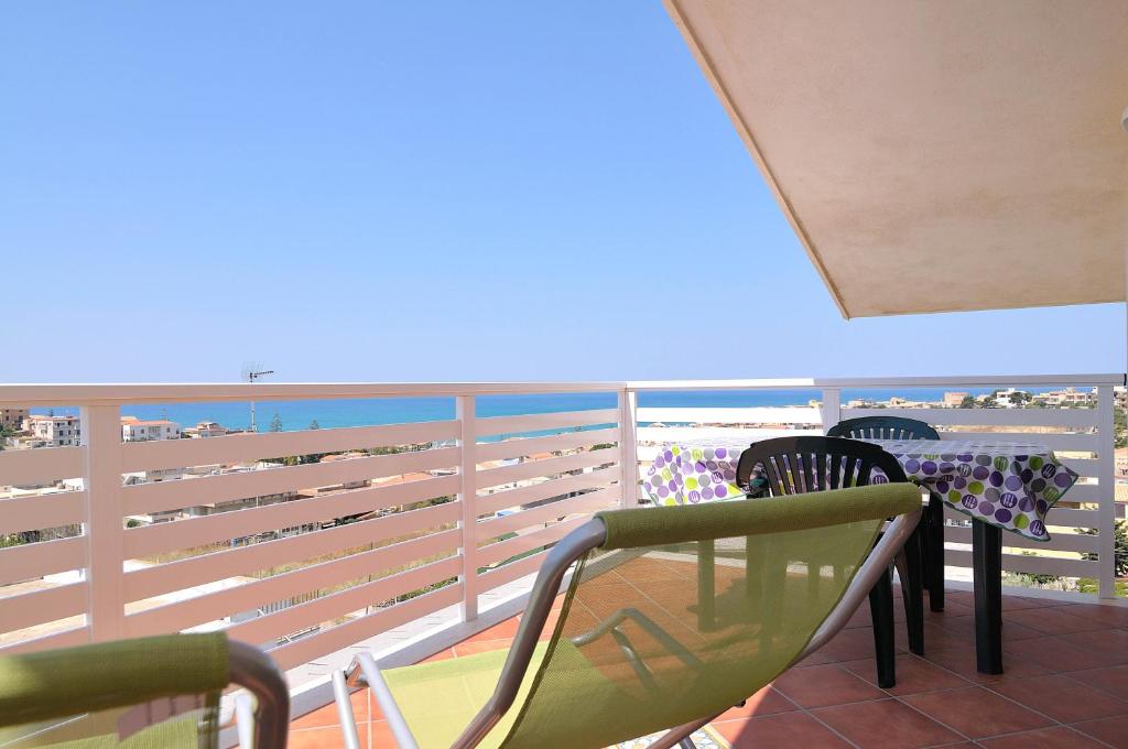 a balcony with chairs and tables on the beach at La dimora del Sole in Scicli