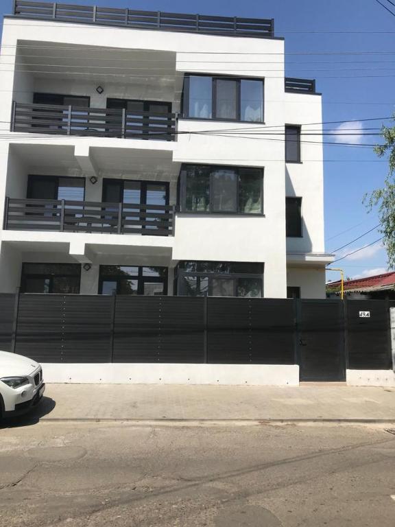 a white building with a black fence in front of it at Casa Bacestianu in Buzău