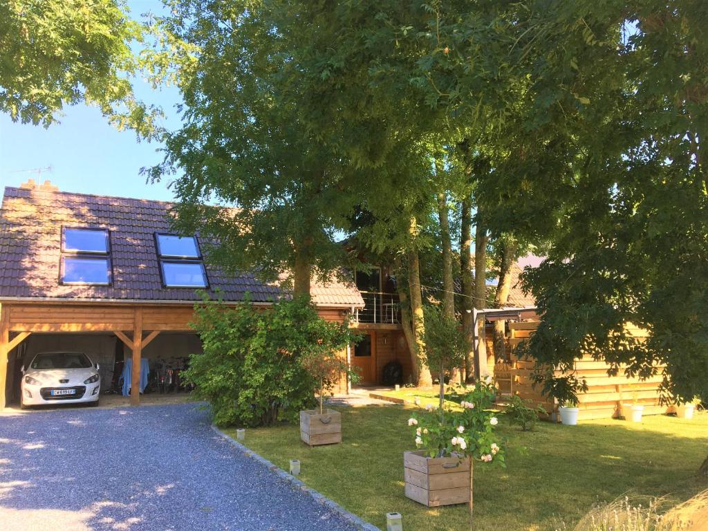 a house with a car parked in front of it at Le gite du Frene in Poses