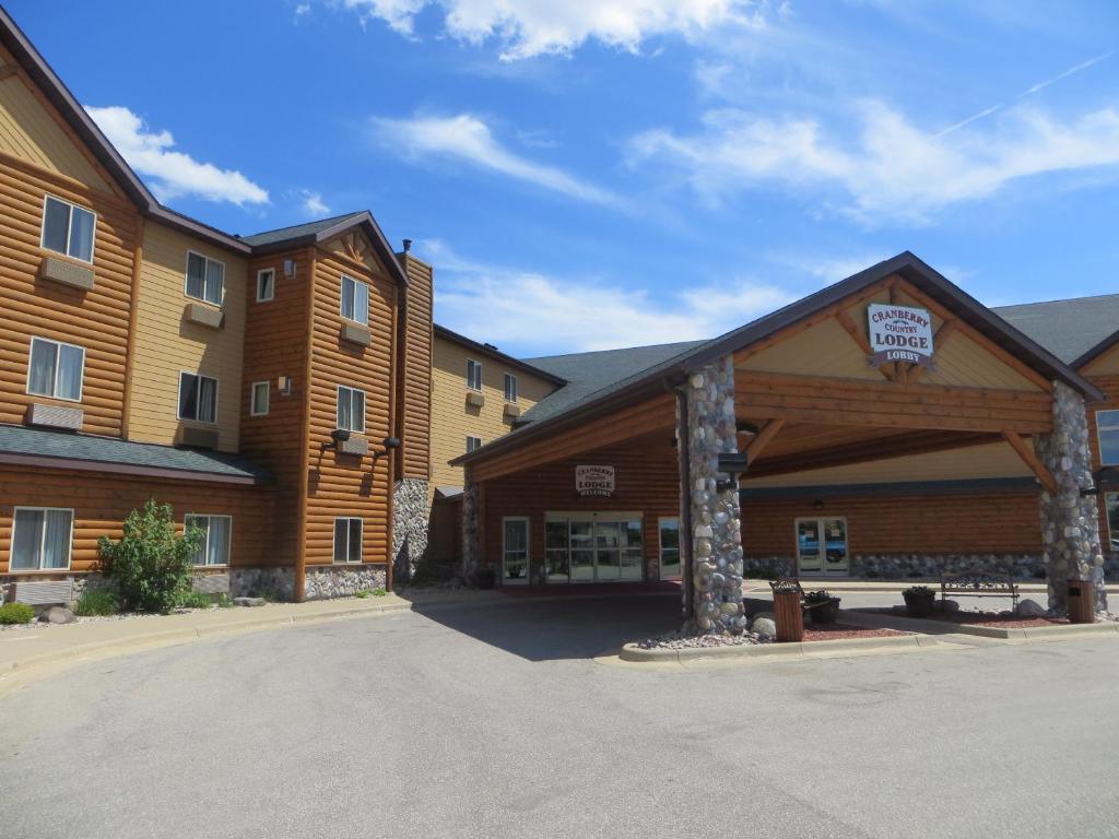a large wooden building with a parking lot in front at Cranberry Country Lodge in Tomah