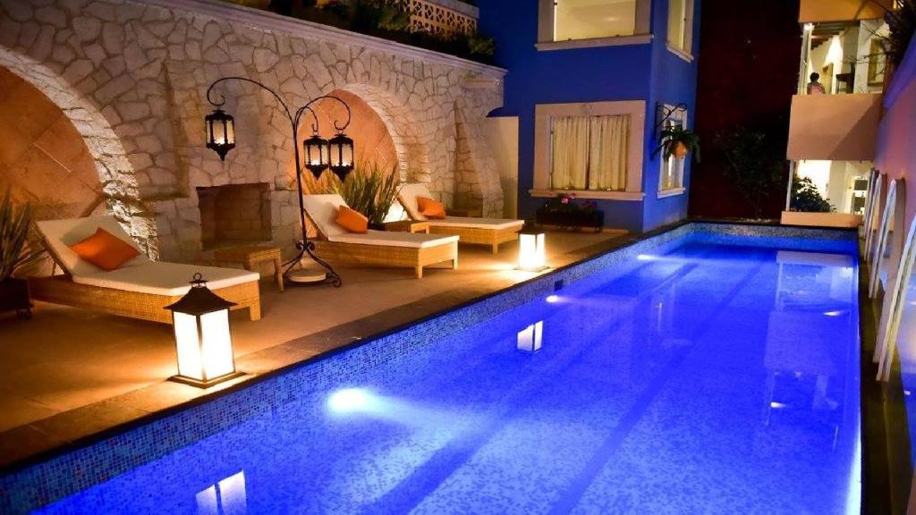 una gran piscina con luces en una casa en Posada de Maria Hotel Boutique & Spa, en Durango