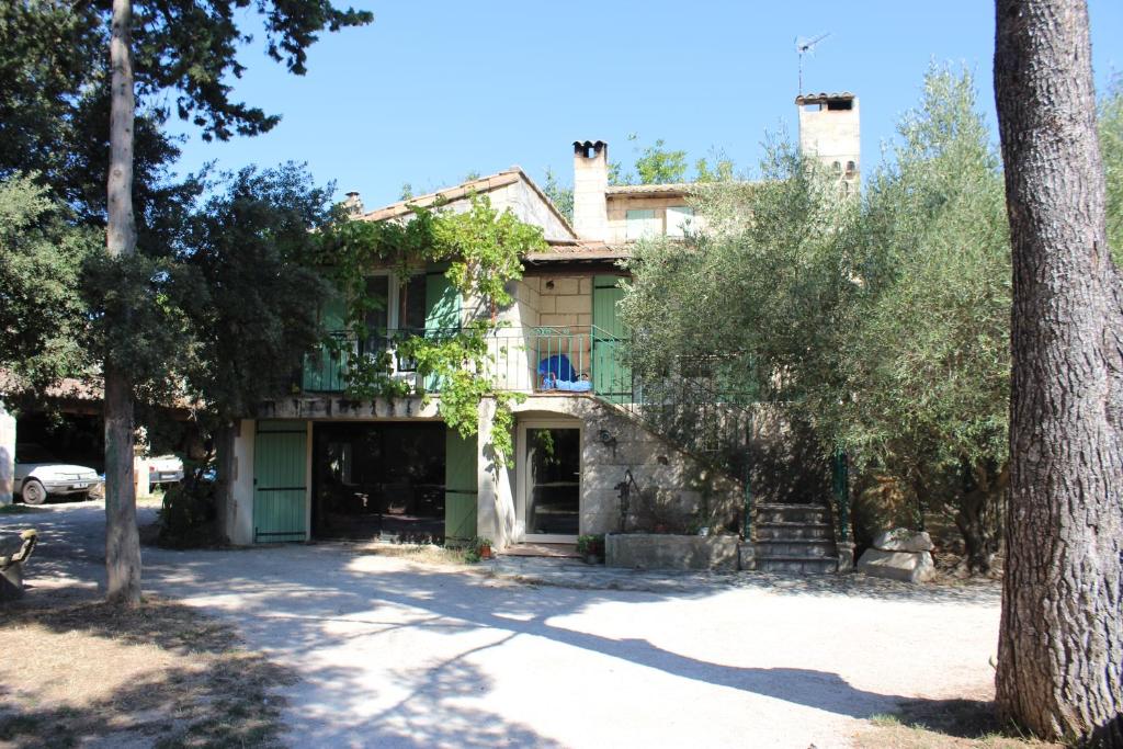 uma casa velha com uma árvore em frente em Le mas de Lucien entre Arles, Nimes, Avignon. em Beaucaire