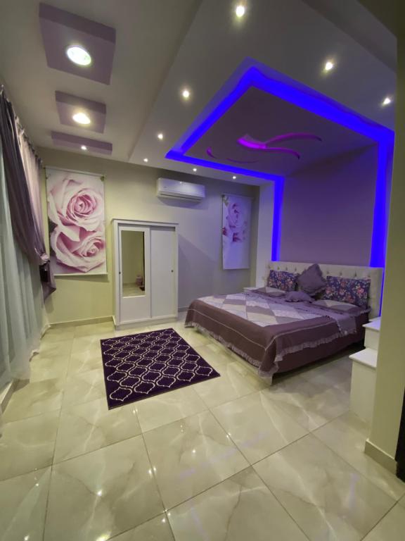 - une chambre avec un lit et un plafond violet dans l'établissement قولدن ستار, à Buraydah