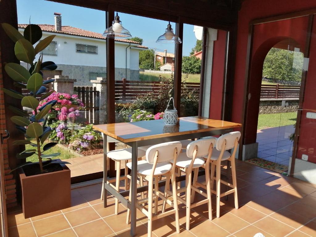 un patio con mesa y sillas en un porche en La Casa Roja Asturias en Hontoria