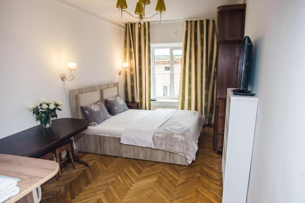sypialnia z łóżkiem, biurkiem i telewizorem w obiekcie Апартаменти на площі Ринок w Lwowie