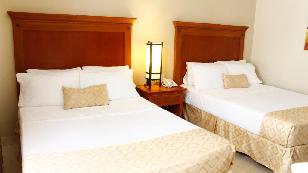 Postel nebo postele na pokoji v ubytování Hotel Magno Tepatitlán