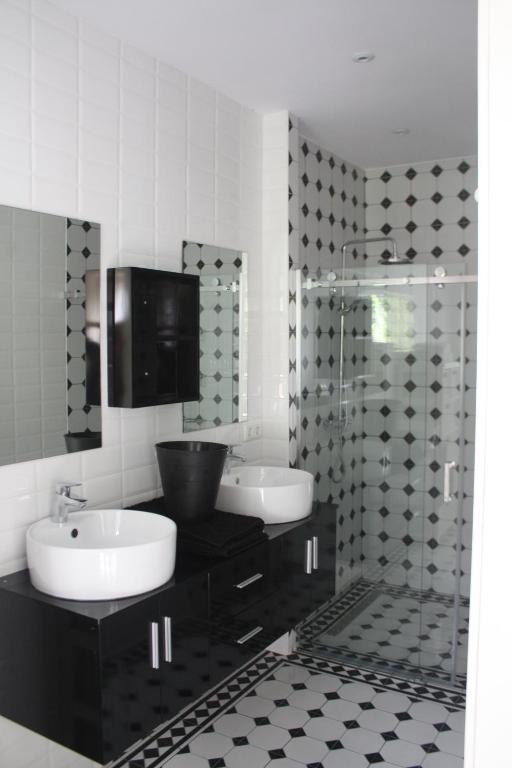 a bathroom with two sinks and a glass shower at dreamingzeeland in Nieuwvliet