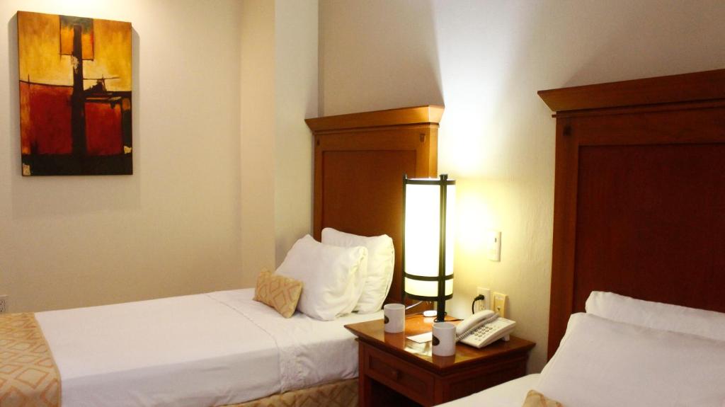 Postel nebo postele na pokoji v ubytování Hotel Magno Tepatitlán