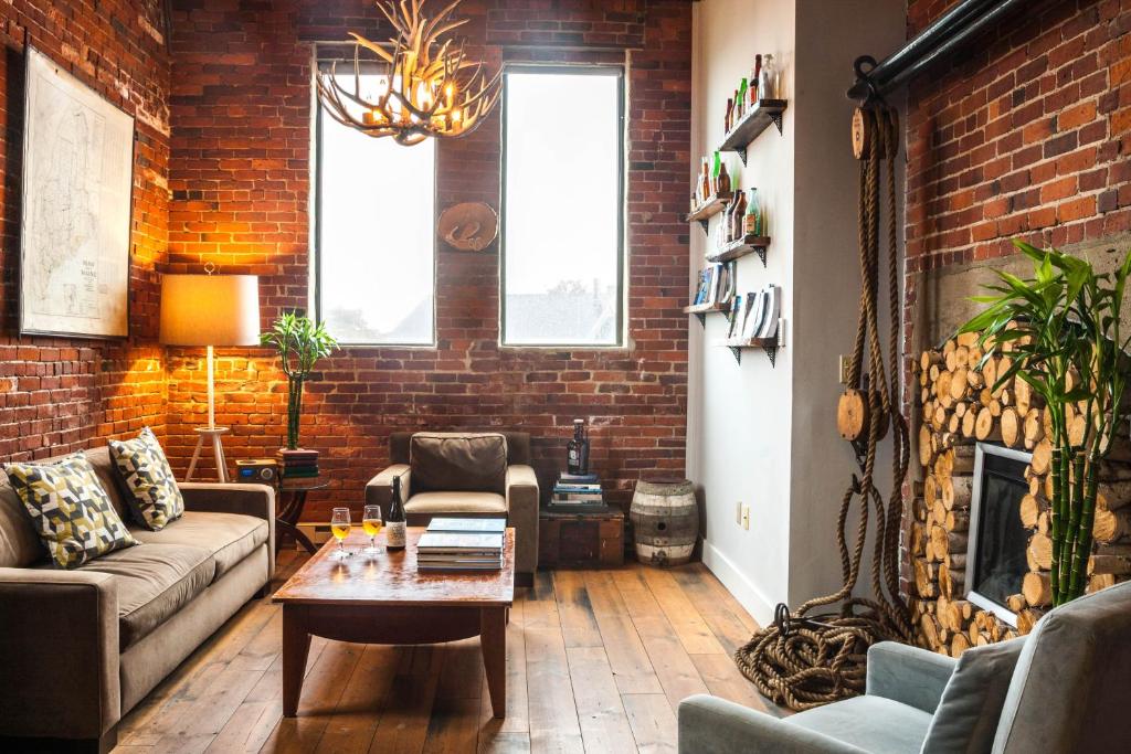 a living room with a couch and a brick wall at Ale House Inn in Portsmouth