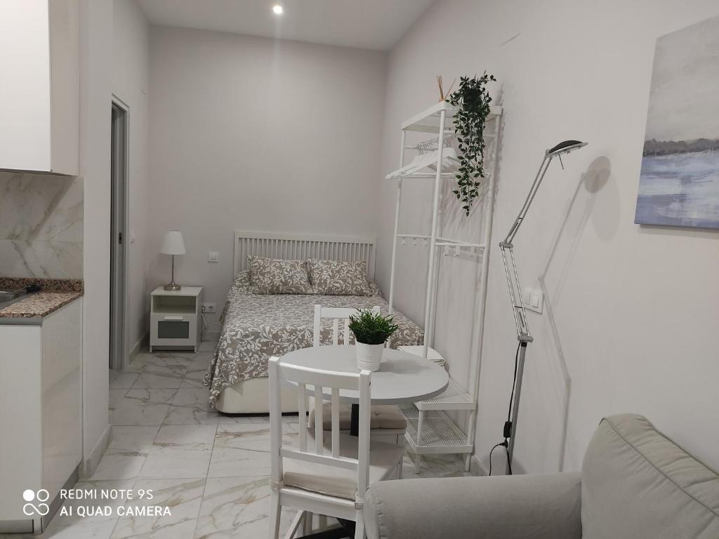 Habitación blanca pequeña con cama y mesa en Estudio 2 personas Wifi fácil acceso centro de Madrid, en Madrid