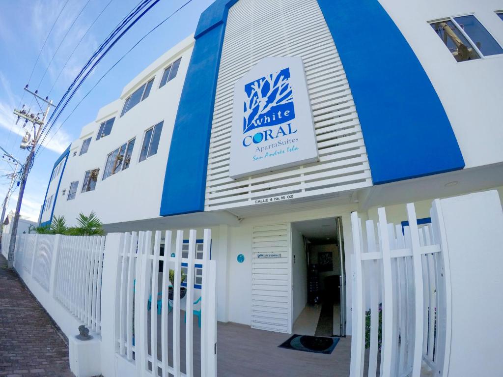 un edificio blanco y azul con un cartel en él en White Coral ApartaSuites, en San Andrés