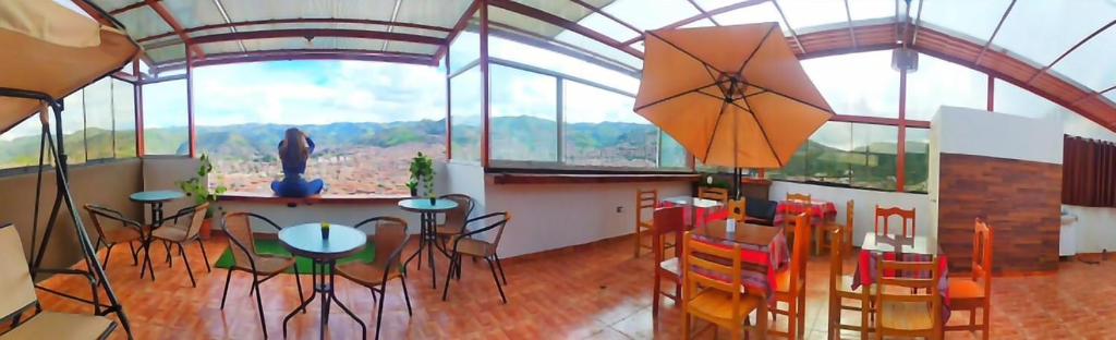 a room with a table and chairs and windows at Casa Mirador in Cusco