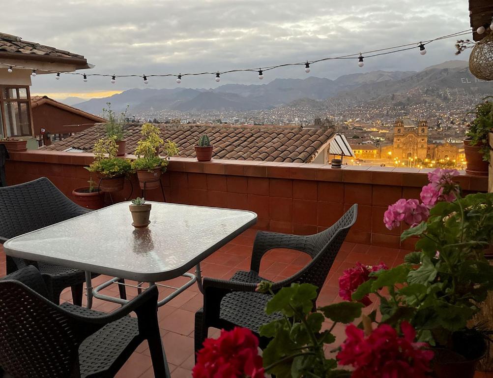 una mesa y sillas en un balcón con vistas en Eco Home View - Guest House, en Cusco