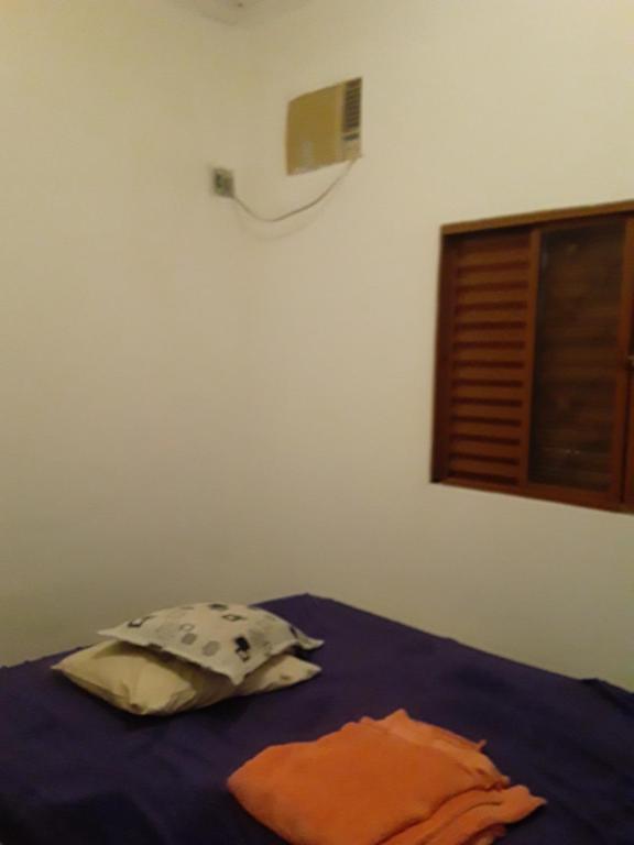 a bedroom with a bed with a pillow and a window at Casa Central Ribeirao in Ribeirão Preto
