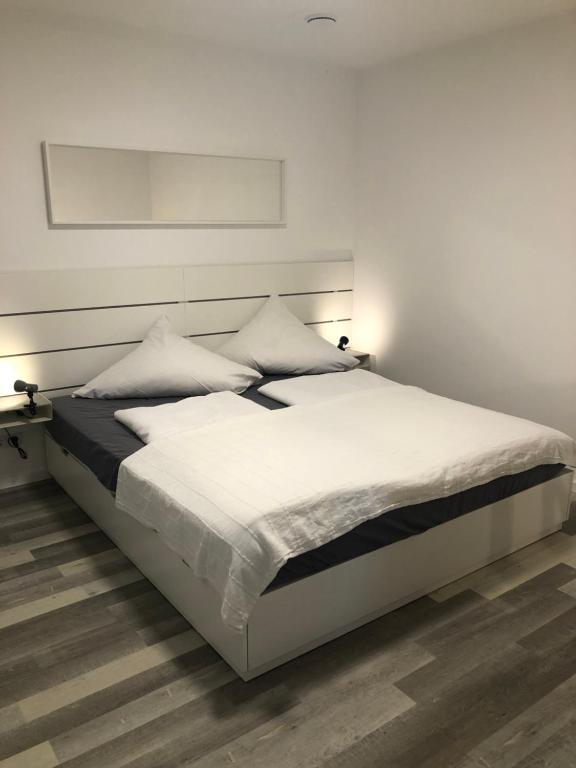 a white bed with white sheets and pillows on it at Apartment Montabaur Heiligenroth in Heiligenroth