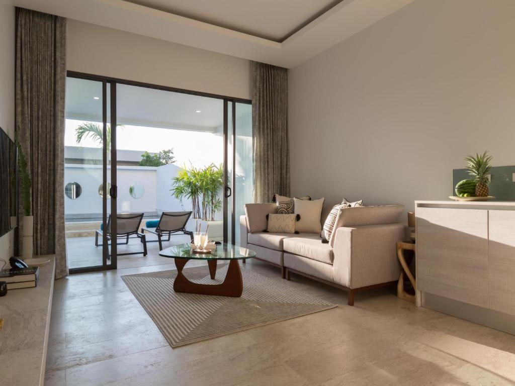 a living room with a couch and a table at Skye Beach Hotel - Koh Samui in Choeng Mon Beach