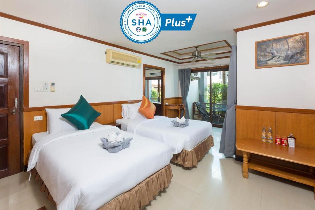 two beds in a hotel room with the shsa plus logo at Sunrise Resort- Koh Phangan - SHA Extra Plus in Haad Rin