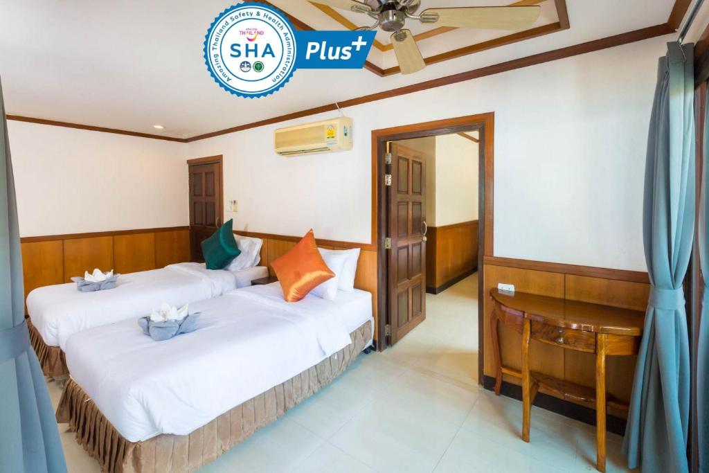 two beds in a room with a sign that says slsa plus at Sunrise Resort- Koh Phangan - SHA Extra Plus in Haad Rin