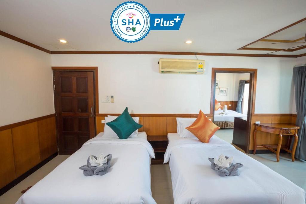 a hotel room with two beds and a sign that reads shahi plus at Sunrise Resort- Koh Phangan - SHA Extra Plus in Haad Rin