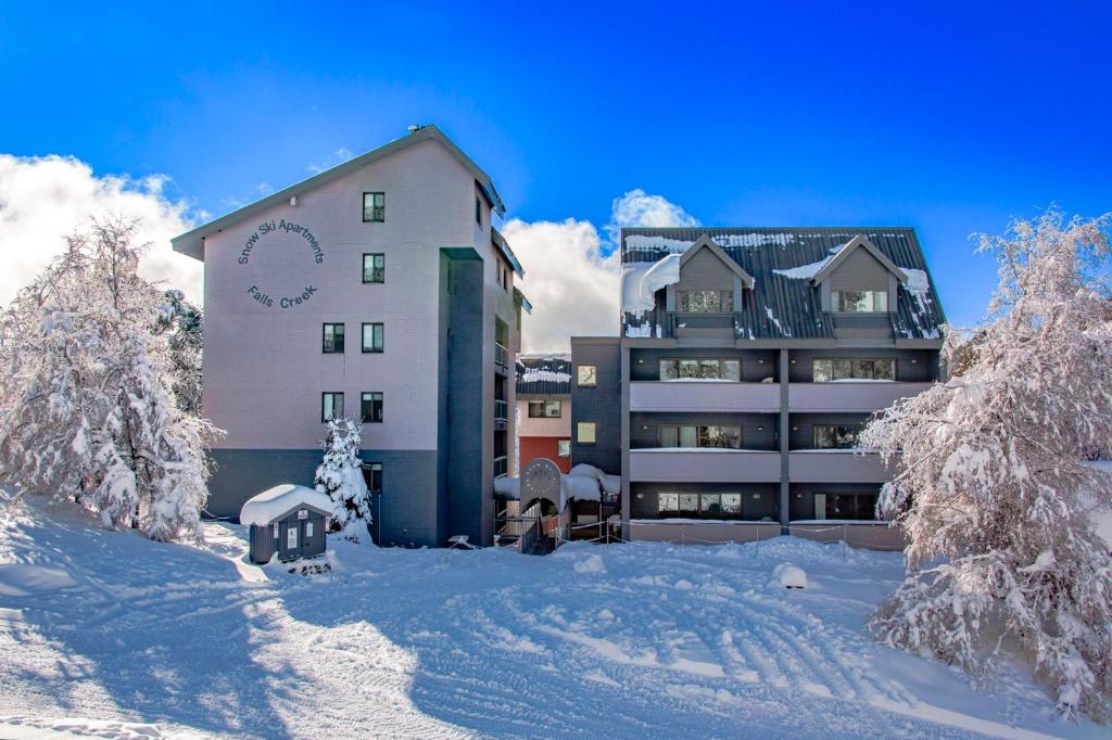 a building in the snow with snow covered trees at Snow Ski Apartments 07 in Falls Creek