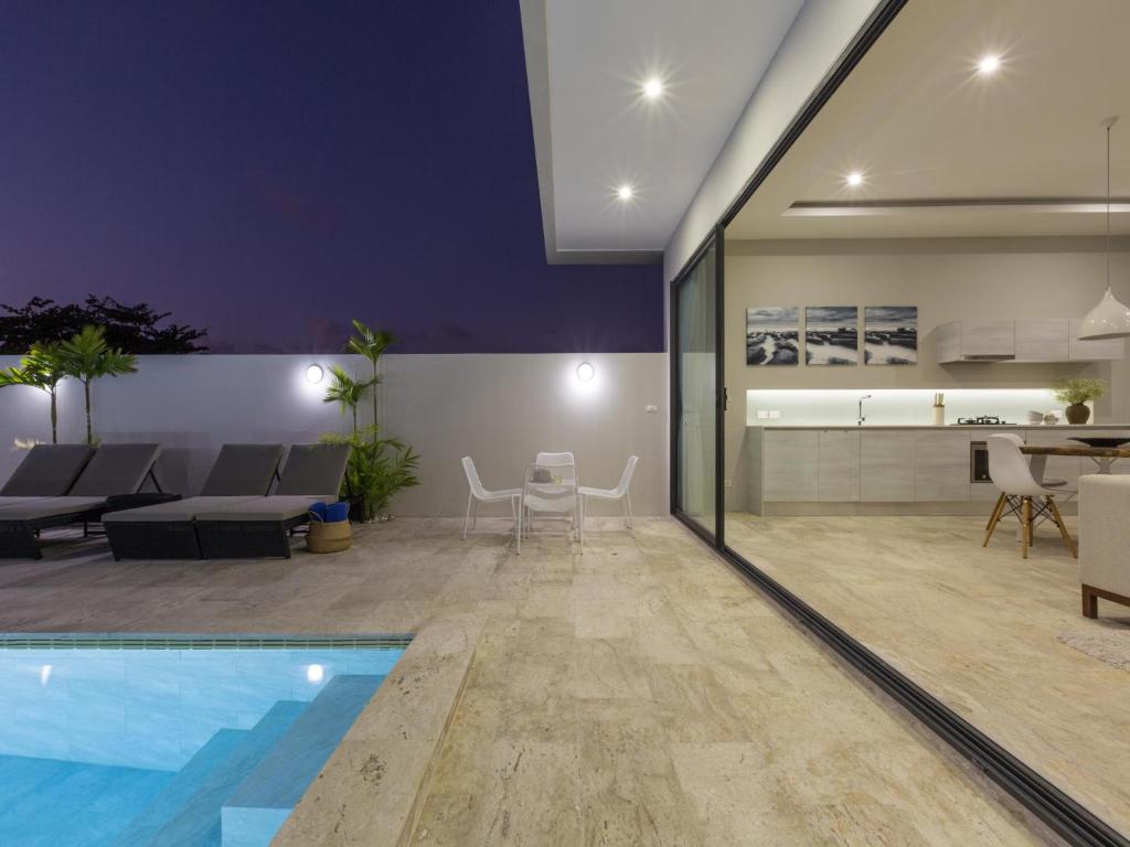 a living room with a swimming pool and a dining room at Skye Beach Hotel - Koh Samui in Choeng Mon Beach