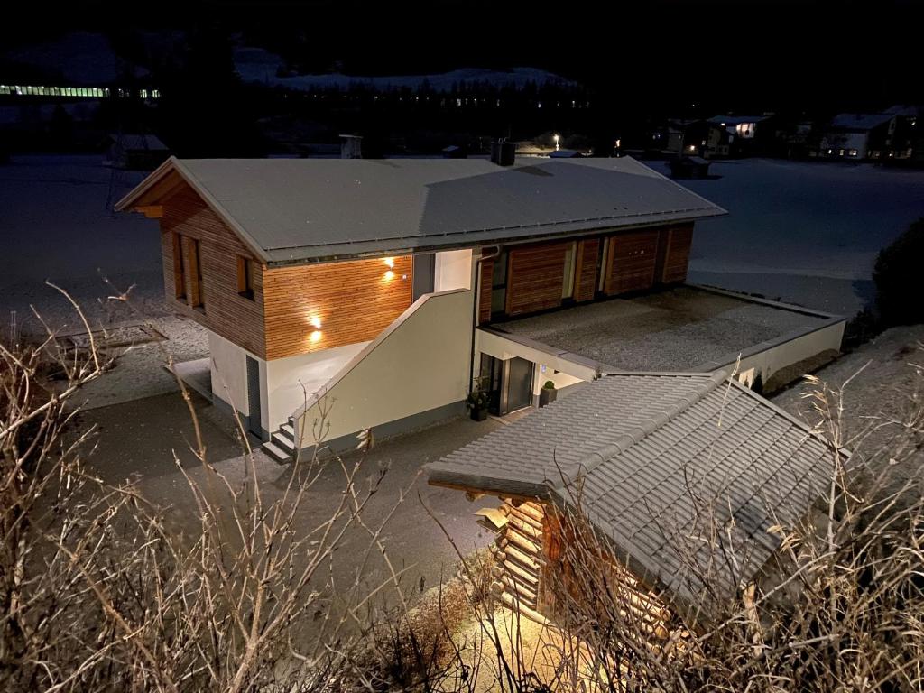 ein kleines Haus mit Lichtern in der Nacht in der Unterkunft Haus Bergleben in Sankt Anton am Arlberg