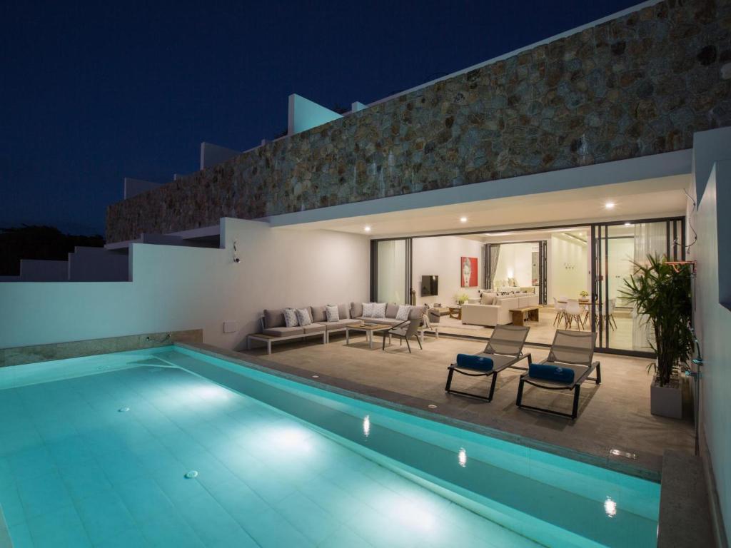 a villa with a swimming pool at night at Skye Beach Hotel - Koh Samui in Choeng Mon Beach