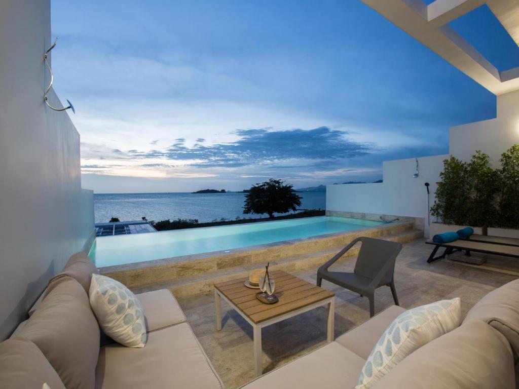 a living room with a couch and a table at Skye Beach Hotel - Koh Samui in Choeng Mon Beach