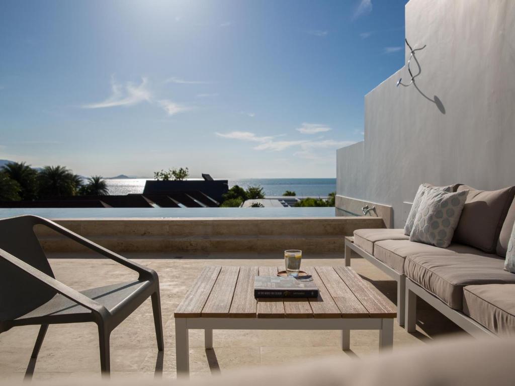 a living room with a couch and a coffee table at Skye Beach Hotel - Koh Samui in Choeng Mon Beach