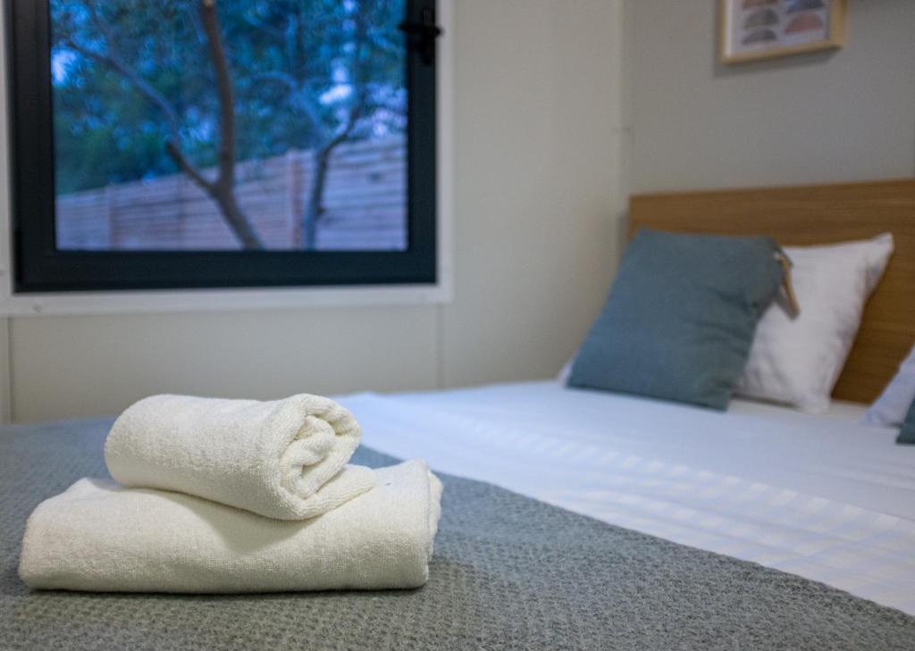 ein Bett mit zwei Handtüchern darüber in der Unterkunft Mobile Homes Vrata Krke in Lozovac