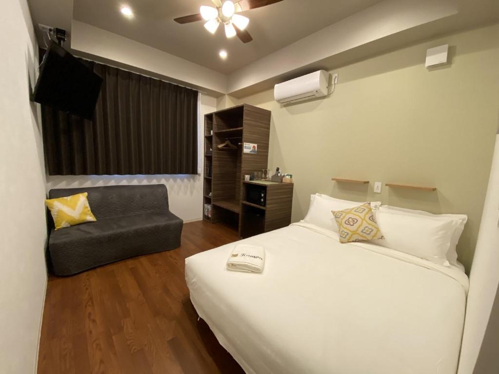 Habitación de hotel con cama y silla en Kainoa Guesthouse, en Tokio