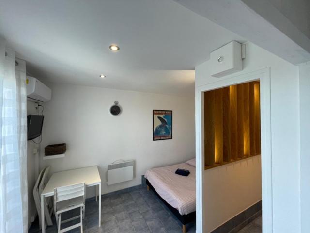 a bedroom with a bed and a table and a desk at GRAND SUD in Hyères