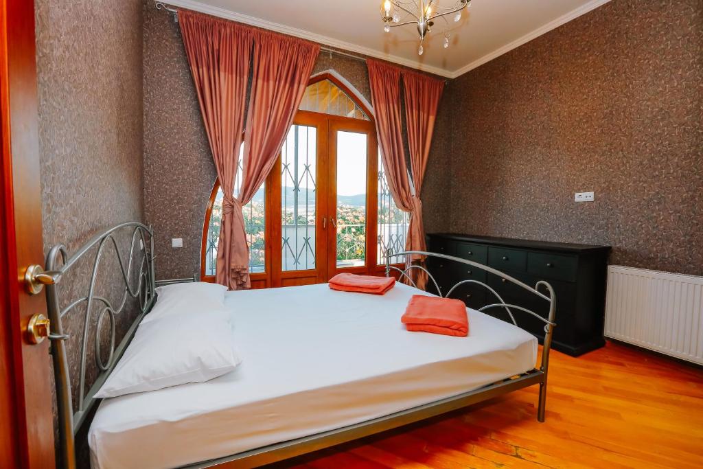 a bedroom with a bed with red pillows on it at Laguna Villa - Pool, Sauna, Events - at Bazaleti Lake in Karsimaantkari